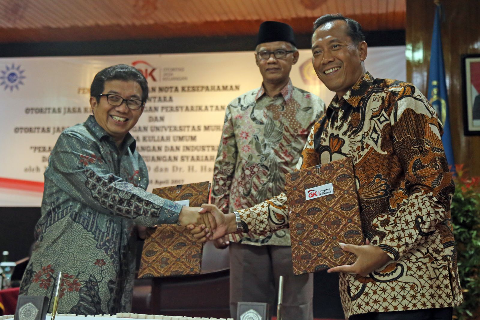 The signing of MoU between UMM Rector Fauzan and OJK Commissioner Chairman  Dr. Mulaiaman D Hadad